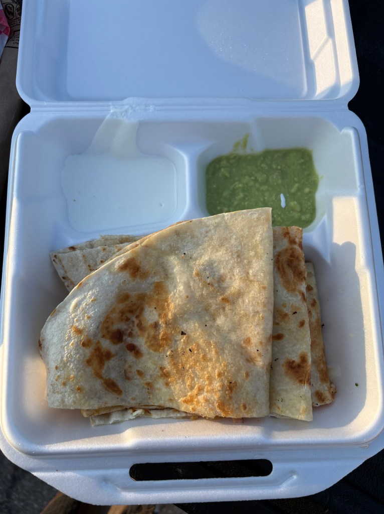Ham and cheese quesadilla in a styrofoam container.